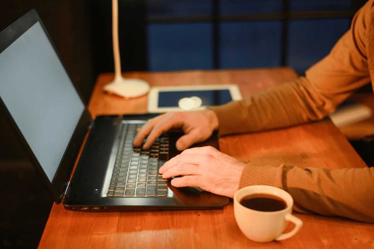 A man focused on his work, typing on a laptop computer with determination and concentration.