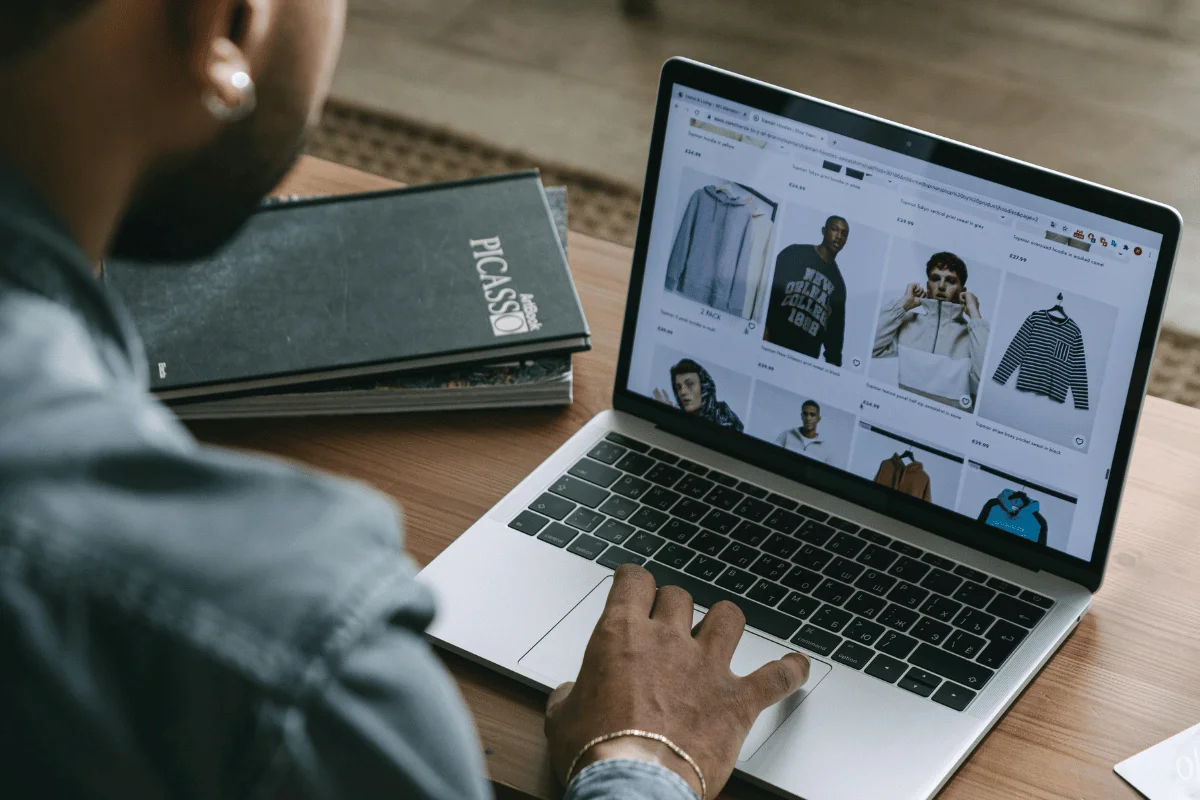 Customer scrolling through eCommerce website displaying clothing items.