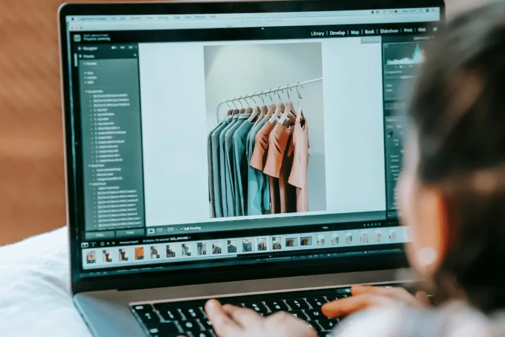Editing a photo of clothing on a laptop.