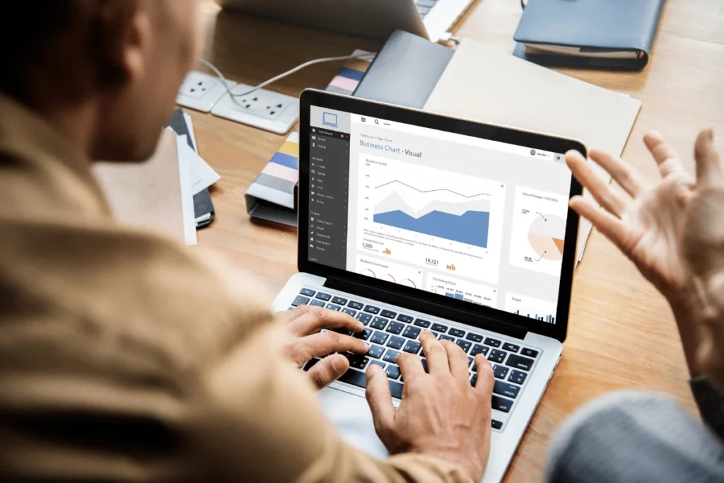 Business professional analyzing dashboard with charts on laptop screen.