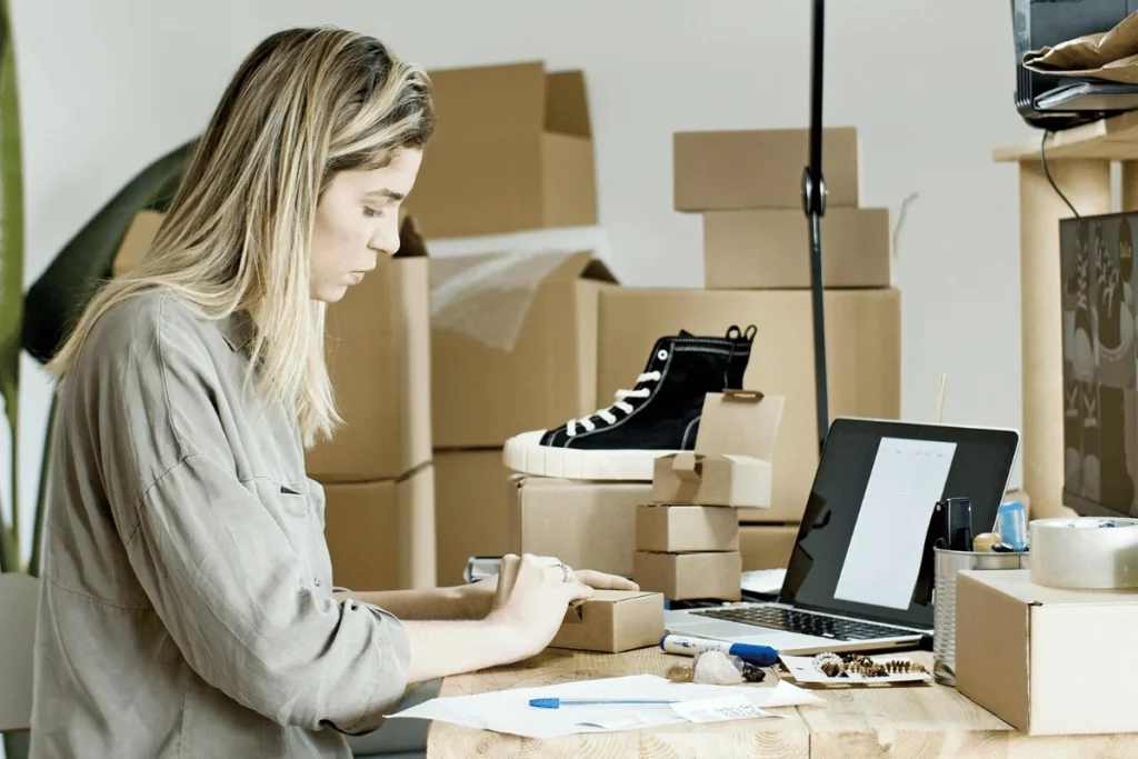 Focused woman at shipping station with laptop.