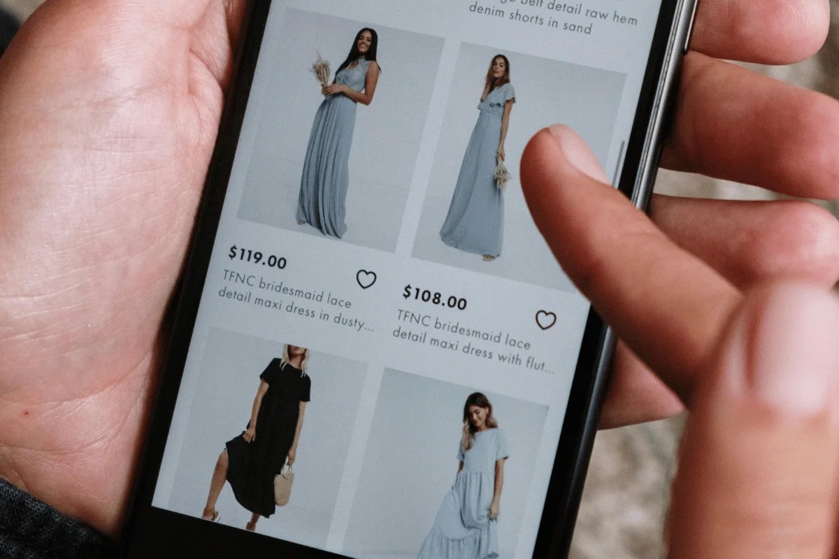 Individual browsing a clothing app, looking at dresses.