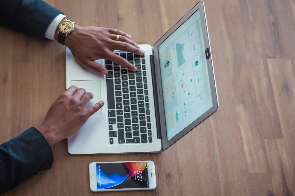 Businessman using a MacBook to study financial charts.
