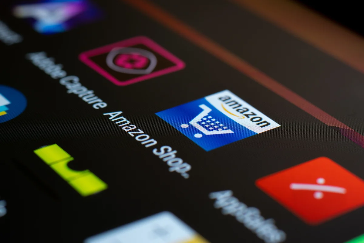 Close-up of a digital screen displaying app icons, including the Amazon shopping app with a blue cart symbol.
